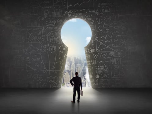Business man looking at key hole