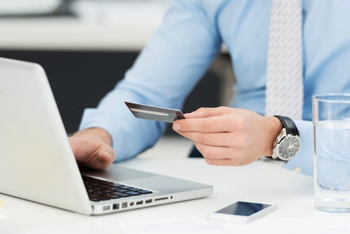 Empresario realizando transacciones en línea con tarjeta de crédito