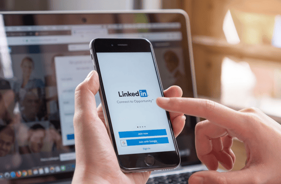 Person holding a cell phone with the LinkedIn login screen.