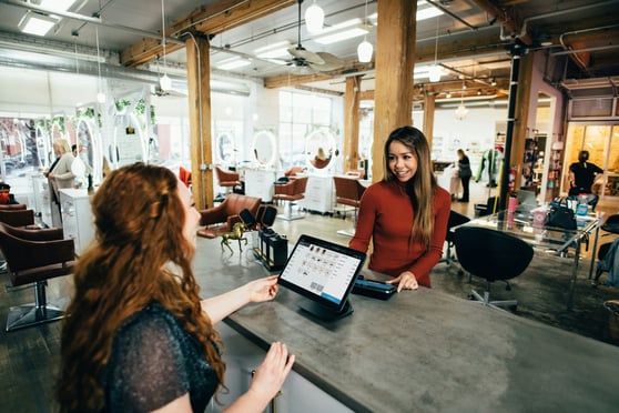 Woman taking order from woman in red shirt.