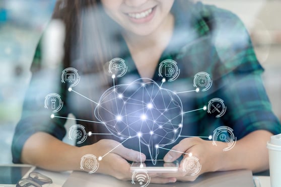 Smiling woman holding a cell phone, with an icon of a electronic brain floating above the phone.
