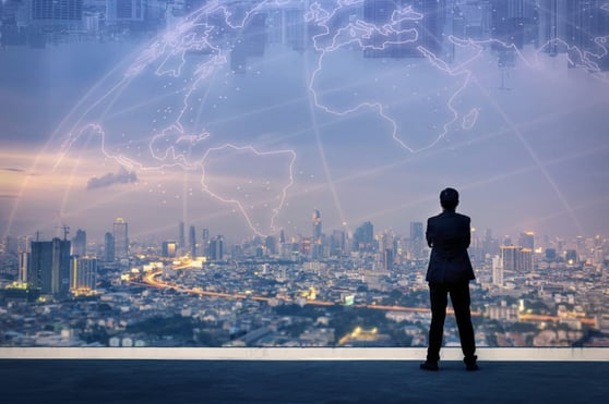 Man standing over a city scape, with an overlay of the planet Earth.