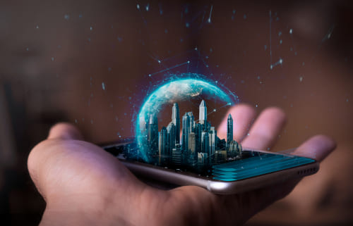 Hand holding a cell phone with a design of a glowing city and planet floating above the screen.