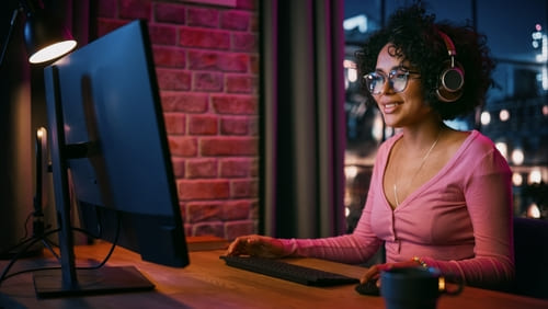 Woman sitting at a desk with a headset.