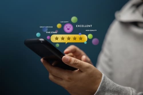 Person holding cell phone with feedback icons.