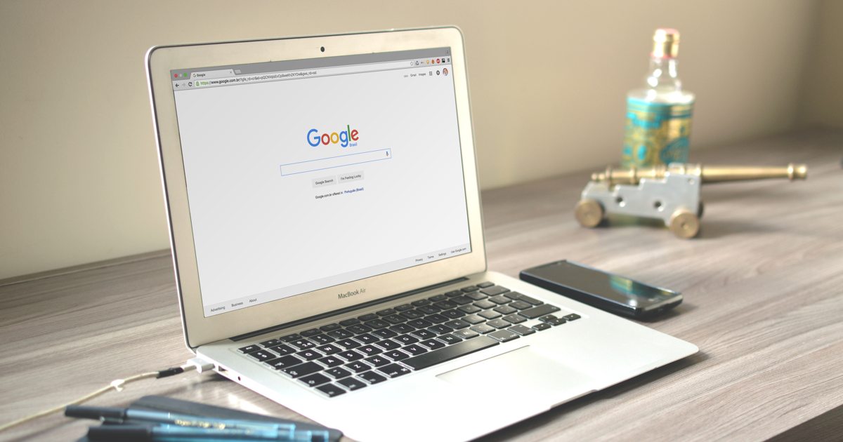 Laptop on a table, with the screen open on Google Search.